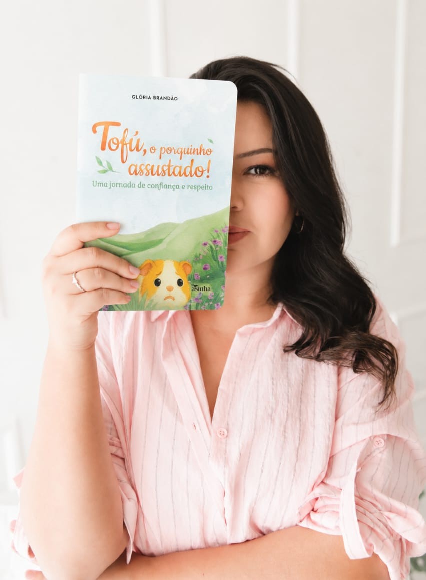 Glória Brandão a segurar o livro Tofú, o porquinho assustado